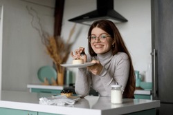 Young Smiling Woman Eating Sweet Cake In Kitchen Home Interior.