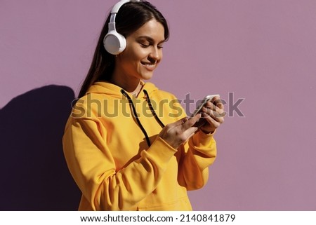 young smiling woman with headphones chating phone