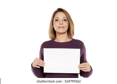 Young Smiling Woman Holding A Blank Sheet Of Paper For Advertising