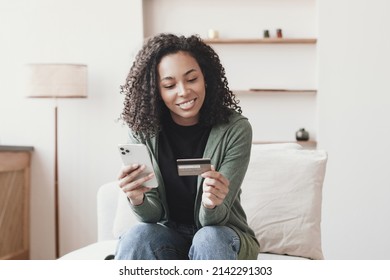 Young Smiling Woman Holding Credit Card, Using Smartphone. Paying Online, Home Shopping, E-commerce, Internet Banking, Spending Money, Finance, Electronic Store Concept