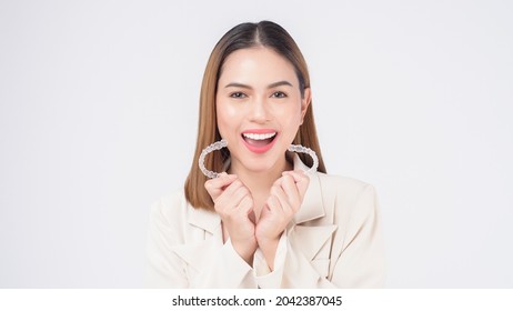 Young smiling woman holding Invisalign braces in studio, dental healthcare and Orthodontic concept - Shutterstock ID 2042387045