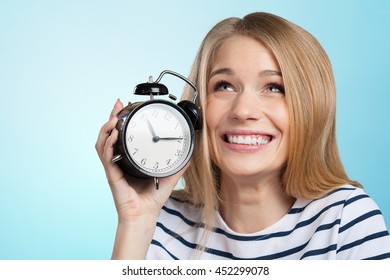 Young Smiling Woman Holds Black Clock