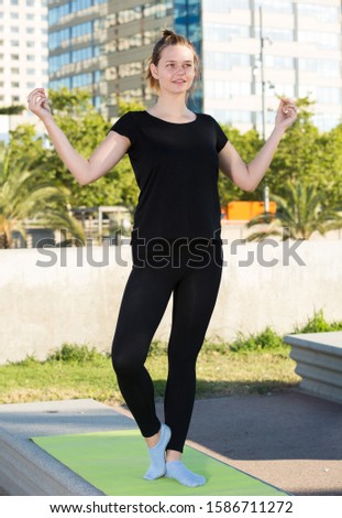 Young smiling woman practicing healthy lifestyle, doing exercises outdoors