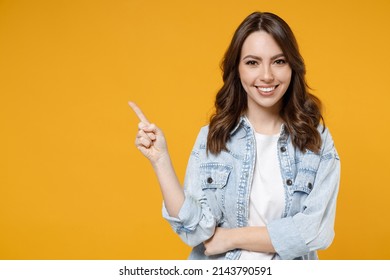 Young smiling woman promoter in denim shirt white t-shirt recommend suggest select advert point index finger aside on workspace commercial promo area mock up copy space isolated on yellow background - Shutterstock ID 2143790591