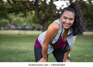 Young Smiling Woman Resting After An Active Fitness Training Outdoor. Happy Latin Girl In Sportswear Resting After Run At Park. Portrait Of Curvy Woman Jogging At Park With Copy Space.