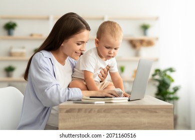Young Smiling Woman Working On Laptop And Taking Care About Baby At Home, Freelancer Lady Spending Time With Infant Son And Using Computer, Enjoying Remote Job During Maternity Leave, Copy Space