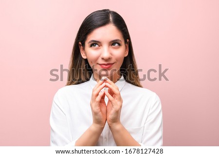 young sneaky woman, scheming something for april first, fools day against pink background