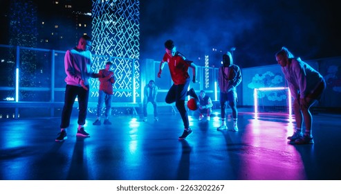 Young Soccer Athlete Performing Freestyle Tricks with a Ball. Footballer Showing Off Juggling Skills. Urban City Spot with Neon Lights, Graffiti on Walls and Scenery with Skyscrapers at Night - Powered by Shutterstock