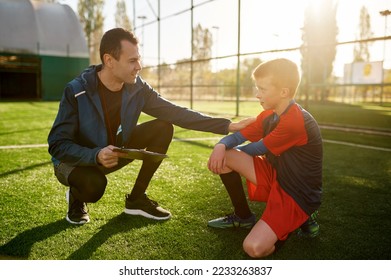 Young soccer coach giving support to little football player - Powered by Shutterstock