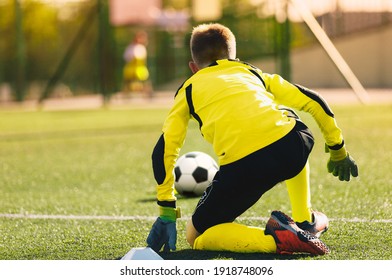 Young Soccer Goalie In Action. Boy Soccer Player Ready To Catch Ball And Safe Goal. Kid Goalkeeper In A Match