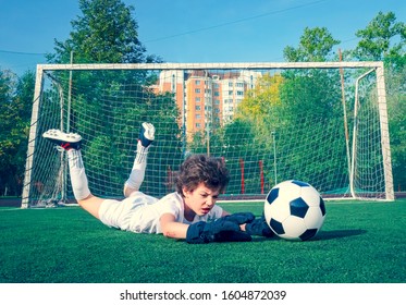 Young Soccer Goalie Attempting To Make A Save. Little Soccer Goalkeeper With Gloves. Kids - Soccer Champion. Boy Goalkeeper In Football Sportswear On Stadium With Ball. Sport Concept. Selective Focus.