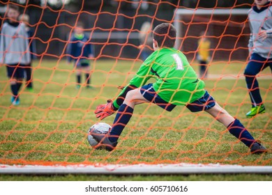 Young Soccer Goalie Attempting To Make A Save