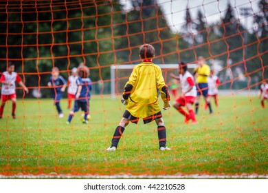 Young soccer goalie defending the net in the rain - Powered by Shutterstock