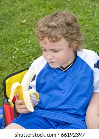 Young Soccer Player Eating Banana As Halftime Snack