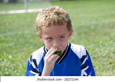 Young Soccer Player Eating Watermelon Snack At Halftime