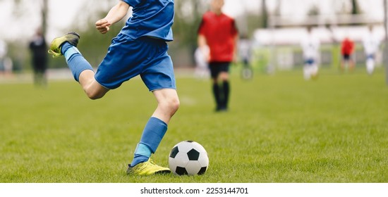 Young Soccer Players Running After the Ball. Running Soccer Football Players. Footballers Kicking Football Match game. Soccer Stadium in the Background - Powered by Shutterstock
