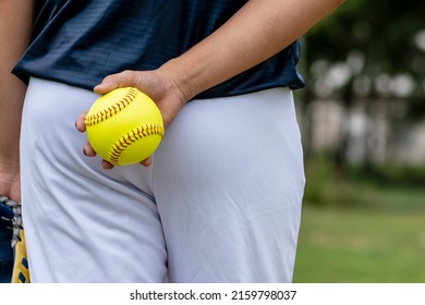 A young Softball player ready to peatch from his position in the outfield.holding a Softball ball in his hands while playing catch in the outfield,with free space. - Powered by Shutterstock