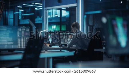 Young Software Developer Working Behind a Desk on a Computer. Engineer Optimizing Software Code of a Quantum Processor, Building a Visual Model of the Quantum Computing Architecture