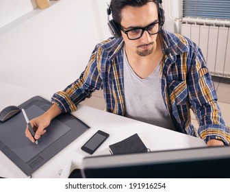 Young Software Engineer Working In Office With Headphones On His Head