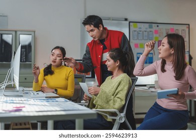 Young software engineers working together on a user interface design project, analyzing data on computer screen and sharing ideas in a modern office
