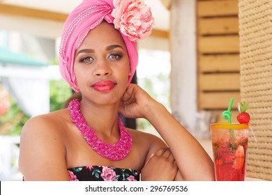 Young South African Zulu Woman Is Wearing Fashion Dress With Makeup Is Sitting Near Bar And Drinking Mojito, Summer Time 