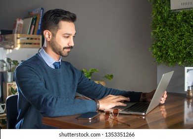 Young South Asian Man Using Laptop In Office