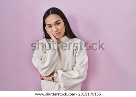 Young south asian woman standing over pink background thinking looking tired and bored with depression problems with crossed arms. 