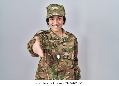 Young South Asian Woman Wearing Camouflage Army Uniform Smiling Friendly Offering Handshake As Greeting And Welcoming. Successful Business. 