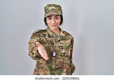 Young South Asian Woman Wearing Camouflage Army Uniform Smiling Cheerful Offering Palm Hand Giving Assistance And Acceptance. 