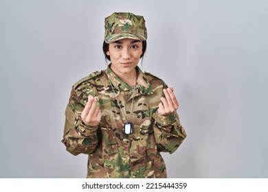 Young South Asian Woman Wearing Camouflage Army Uniform Doing Money Gesture With Hands, Asking For Salary Payment, Millionaire Business 