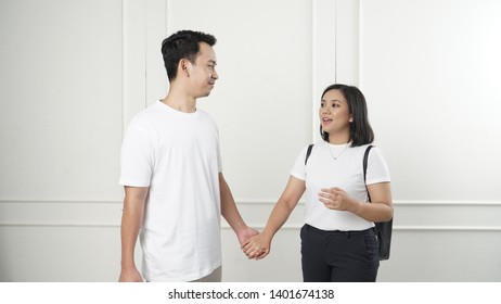 Young South East Asian Couple Holding Hands And Walking 