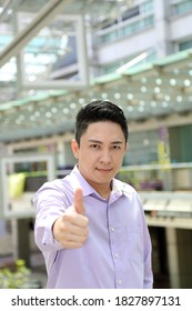 Young South East Asian Man Business Office Outdoor Stand Look At Camera Thumbs