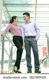 Young South East Asian Man Woman Business Colleague Outdoor Stand On Staircase Talk Discuss Smile