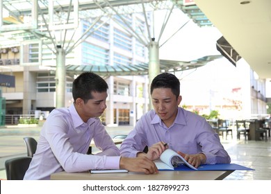 Young South East Asian Middle Eastern Man Business Colleague Outdoor Cafe Chair Table Meeting Talking Discussing File Paper