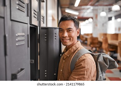 A Young South East Asian Student Stands In Front Of Lockers In A College Hallway
