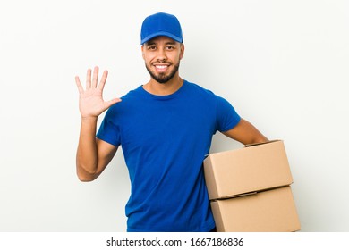 Young South-asian Delivery Man Smiling Cheerful Showing Number Five With Fingers.