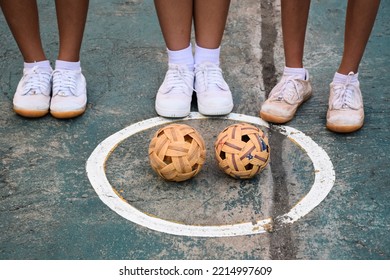 Young southeast asian female sepak takraw players standing near the balls in the serving center of the court, outdoor sepak takraw playing after school, soft and selective focus, - Shutterstock ID 2214997609