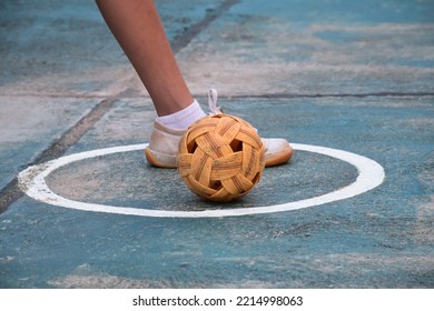Young southeast asian female sepak takraw player step her left foot near the ball in the serving center area of the court, outdoor sepak takraw playing after school, soft and selective focus, - Shutterstock ID 2214998063