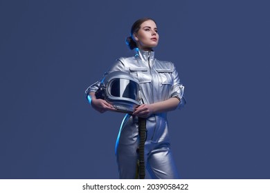 Young Spacewoman In Silver Suit Holding Helmet