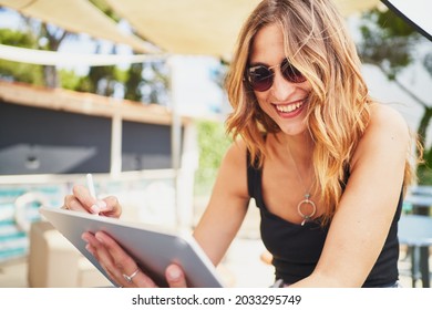 Young Spanish Cheerful Woman Using Tablet In Cafeteria