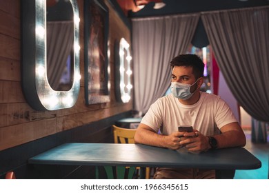 A Young Spanish Guy Wearing A Face Mask Is Sitting In A Cafe; Social Life During Pandemic