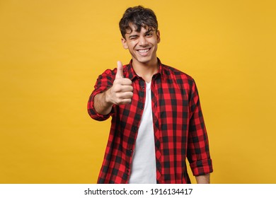 Young spanish latinos attractive handsome smiling stylish happy fashionable student man 20s wear red checkered shirt look camera show thumbs up gesture isolated on yellow background studio portrait - Powered by Shutterstock