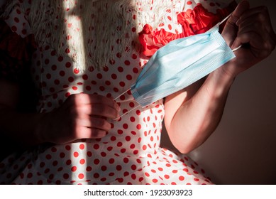 Young Spanish Woman Wearing A Red Flamenco Dress And A White Manila Shawl. She Is Holding A Blue Disposable Mask