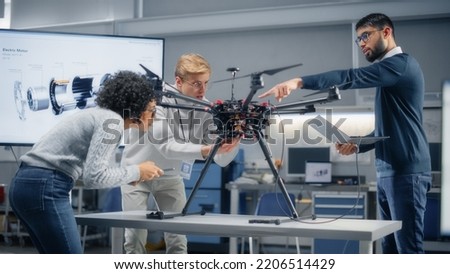 Young Specialists Connecting Drone to a Laptop. Engineers Try to Make Jobs Safer, Easier and More Efficient by Automated Contactless Delivery Machines. Professionals Work in Aviation Industry.