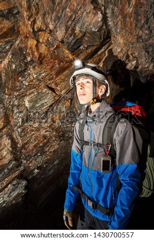 Young speleologist exploring a cave