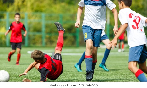 Young sport boys in red sportswear running and kicking a  ball on pitch. Soccer youth team plays football in summer. Activities for kids, training	 - Powered by Shutterstock