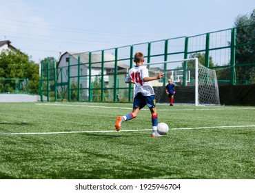 Young Sport Boys In White Sportswear Running And Kicking A  Ball On Pitch. Soccer Youth Team Plays Football In Summer. Activities For Kids, Training	