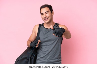 Young sport caucasian man with sport bag isolated on pink background with thumbs up because something good has happened - Shutterstock ID 2344339241