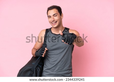 Young sport caucasian man with sport bag isolated on pink background with thumbs up because something good has happened