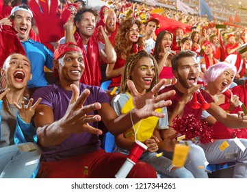 Young Sport Supporter Happy Fans Cheering At Stadium. Group Of Young Woman And Man Support The Football Team During The Match